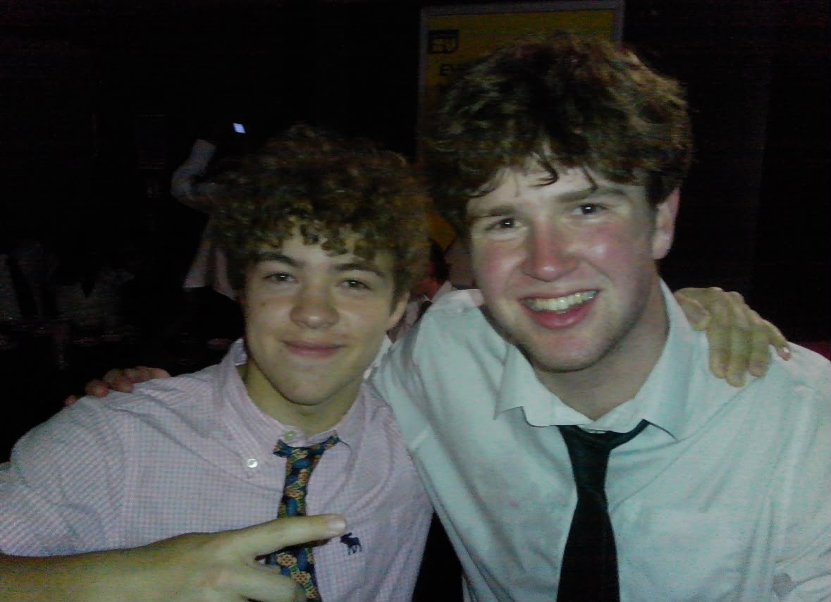 Two members with an arm round each other, dressed up for a social
